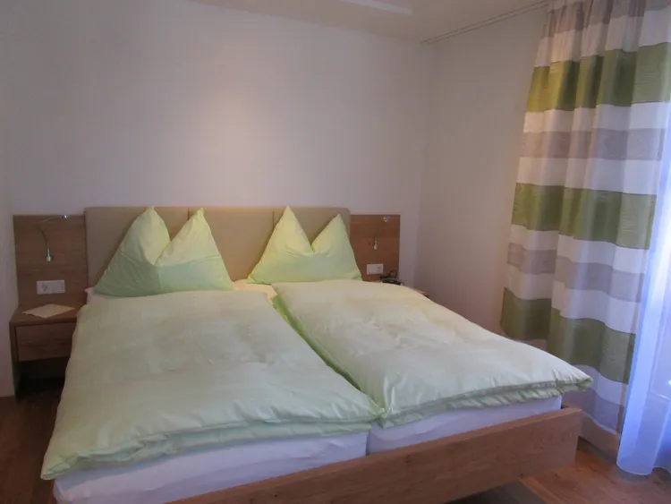 Appartement Hochglocker: Doppelbett mit hellgrüner Bettwäsche