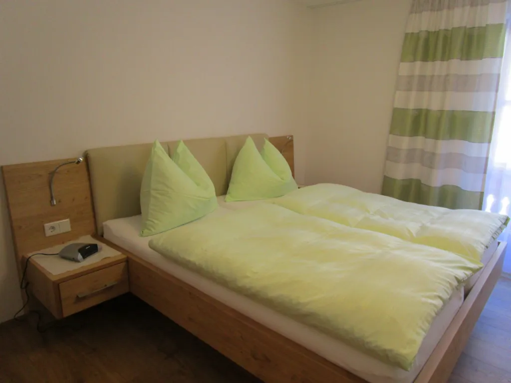 Appartement Schneeberg: Doppelbett mit hellgrüner Bettwäsche