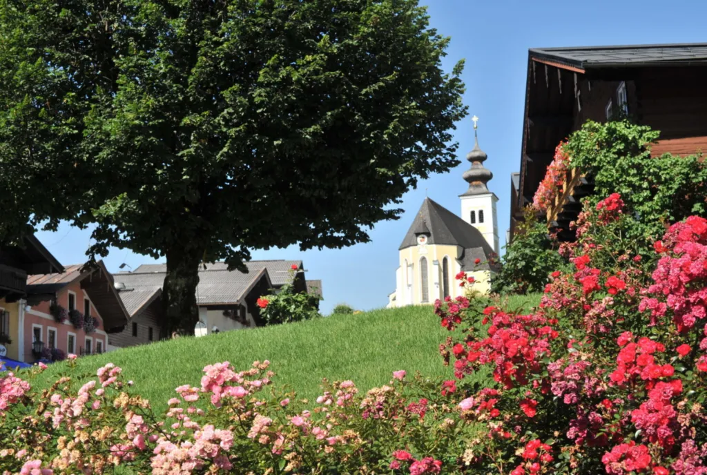 Blühender Garten des Sunnhäusl mit Blick auf die Pfarrkirche St. Veit