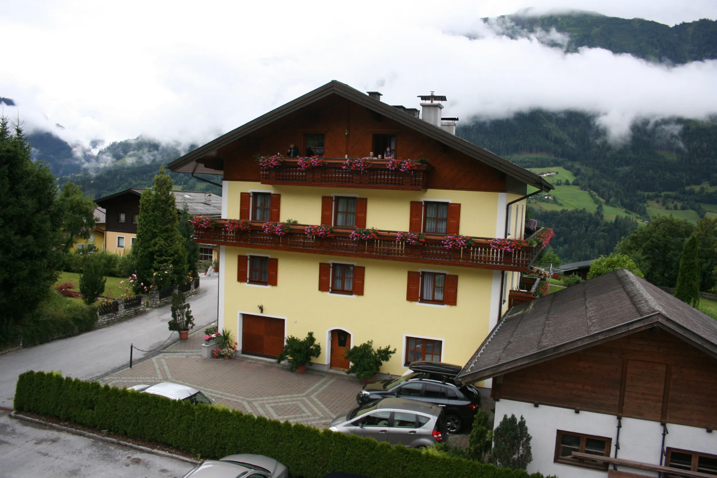 Einfahrt und Parkplatz vor dem Sunnhäusl, dahinter die Berge