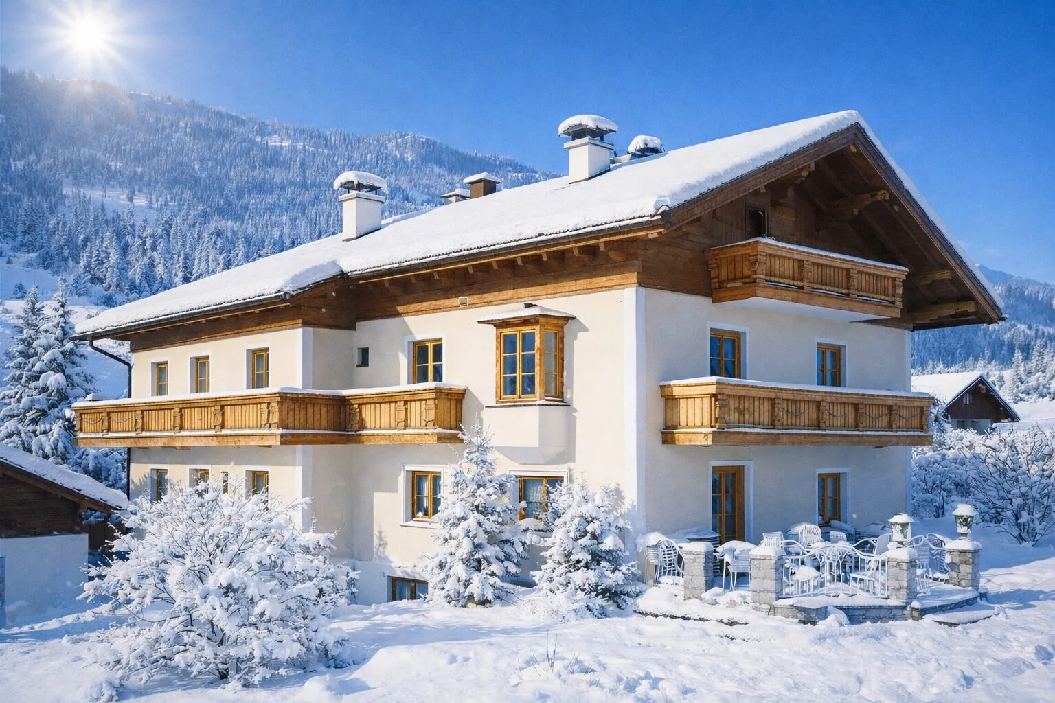 Das Sunnhäusl im Winter mit verschneitem Garten und Sonnenschein