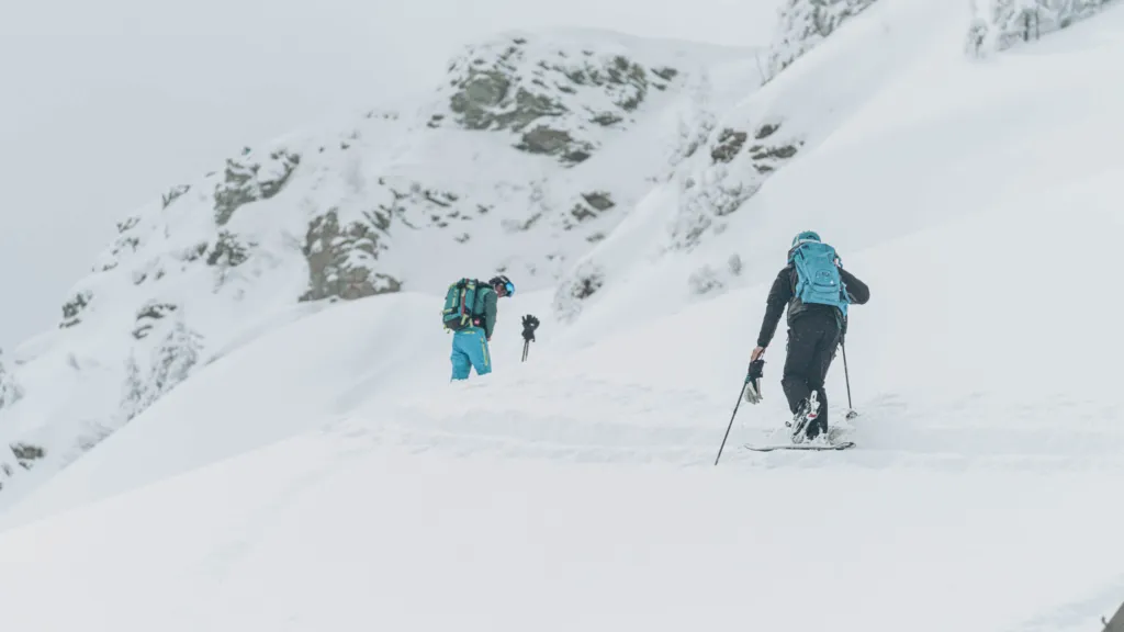 Zwei Skitourengeher steigen durch den Schnee auf