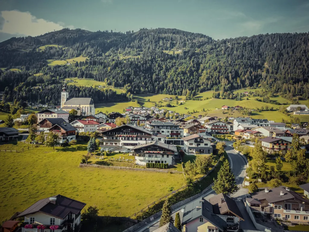 St. Veit im Pongau im Sommer von oben: Ortskern mit Pfarrkirche, Häuser und grüne Wiesen