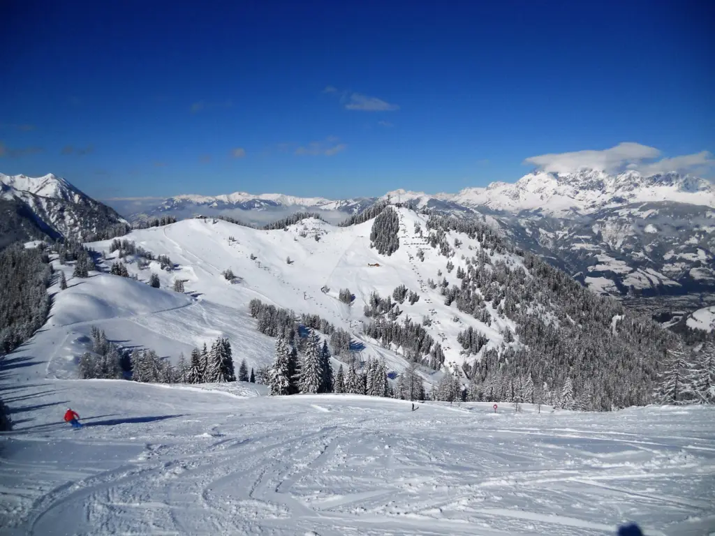 Verschneite Skihänge und Berggipfel unter blauem Himmel