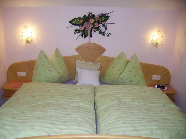 Doppelzimmer mit hellem Kopfteil und grün karierter Bettwäsche